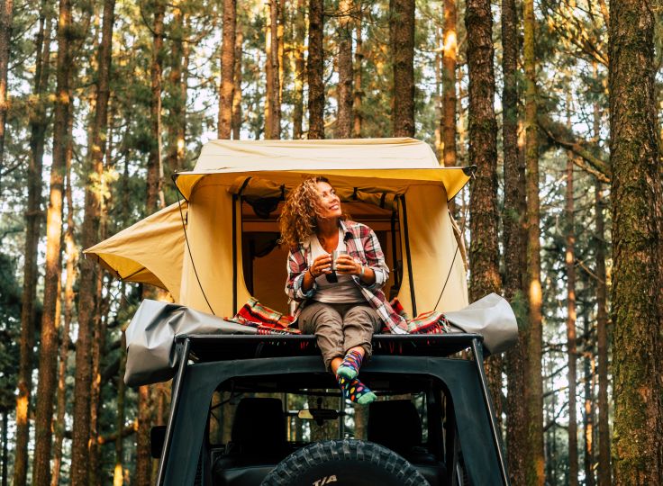 Woman sitting on top of car 