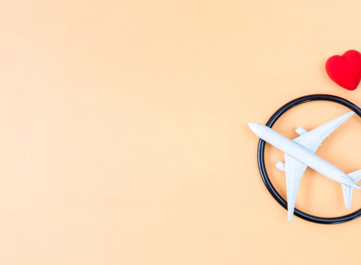 Plane and stethoscope over orange background