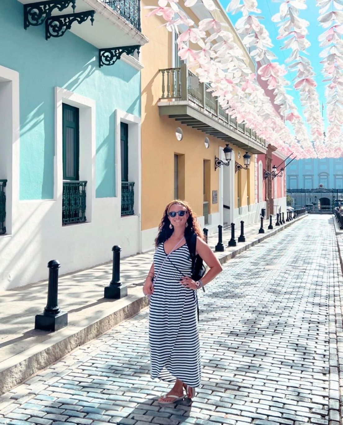 Woman standing in street with ocean behind her